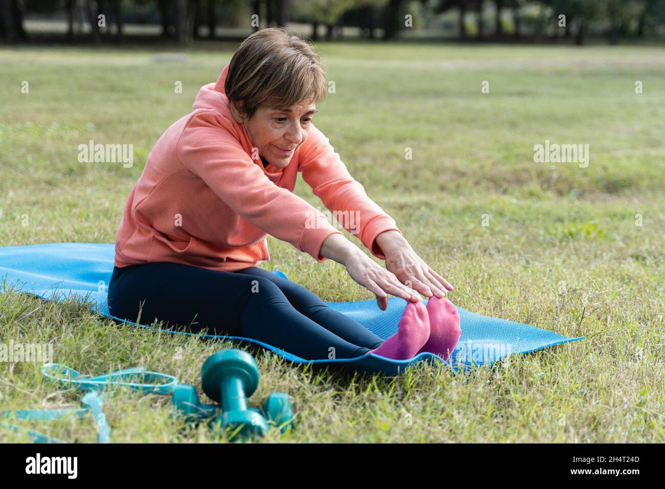 Femme senior faisant la routine de sport de yoga au parc de la ville - Focus sur les mains Banque D'Images