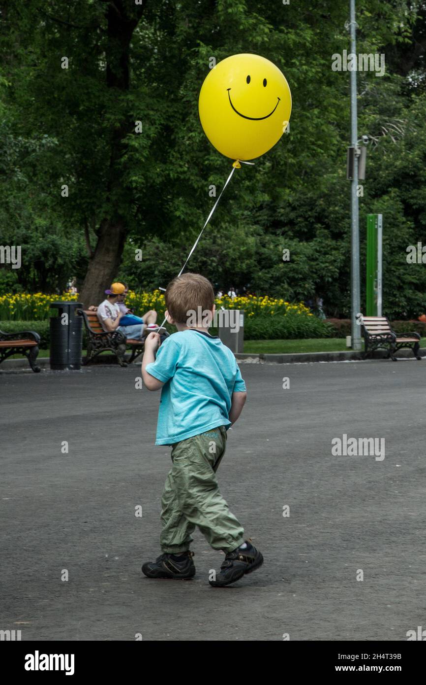 Garçon avec ballon jaune souriant Banque D'Images