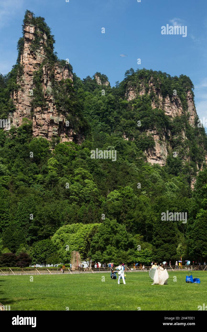 Un jeune couple pose pour des photos de mariage dans un champ ouvert dans le parc forestier national de Zhangjiajie, en Chine. Banque D'Images