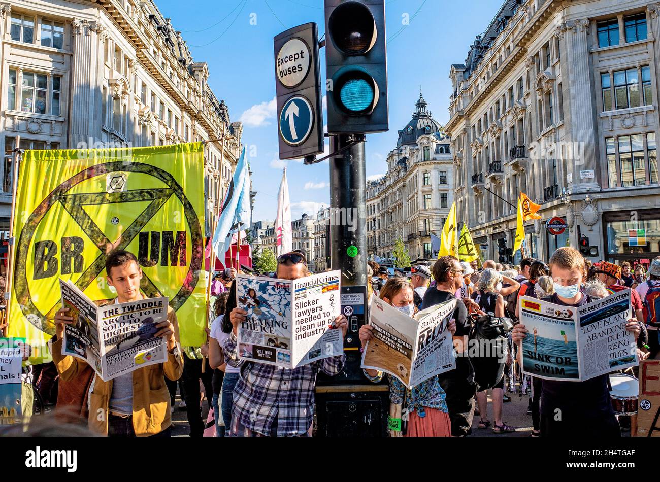 LES manifestants DE XR lisent les journaux Oxford Circus London Banque D'Images
