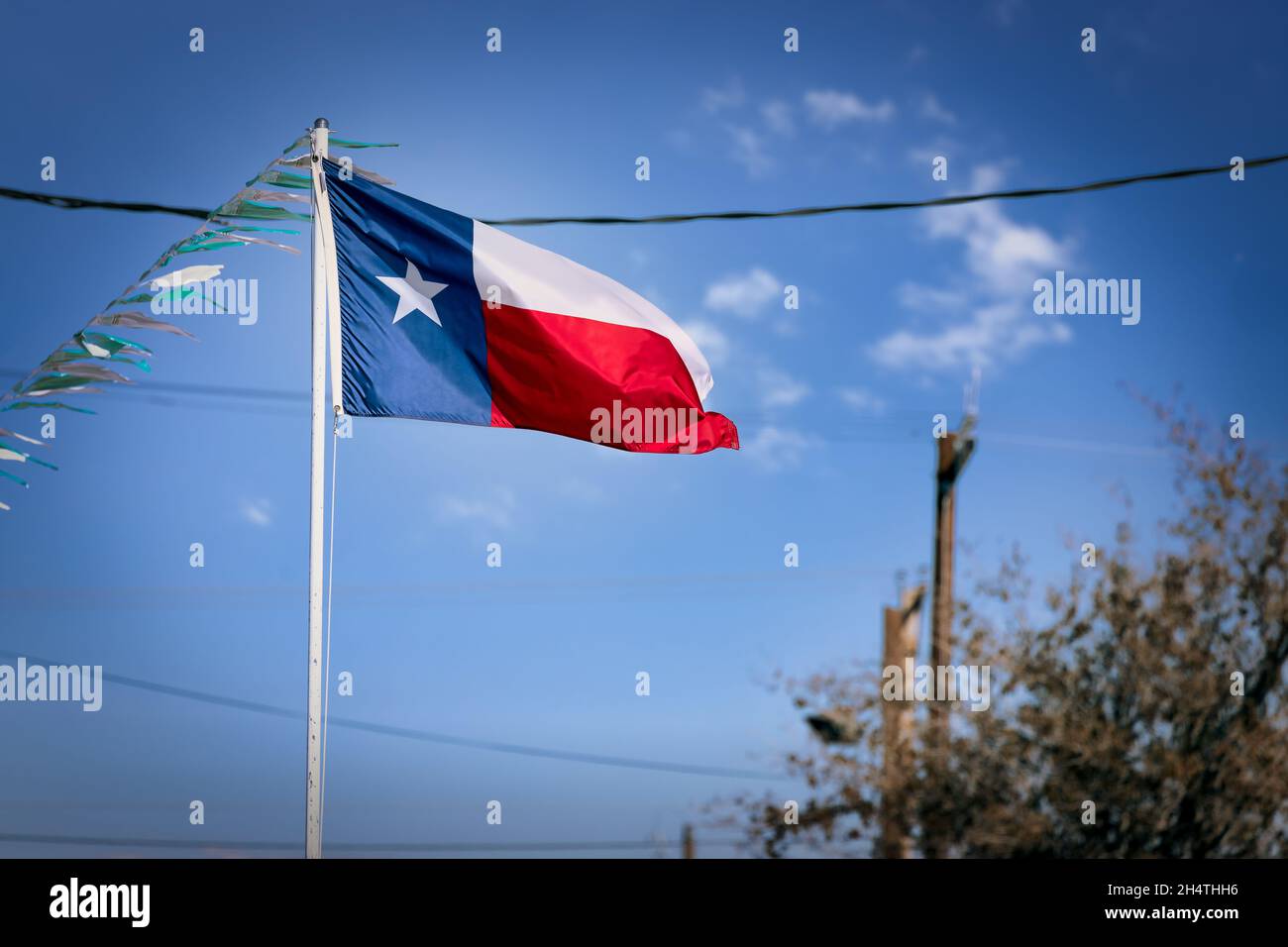 Le drapeau d'État du Texas, ou drapeau d'étoile de Lone, volant fièrement dans la petite ville frontalière de Fabens, Texas. Banque D'Images