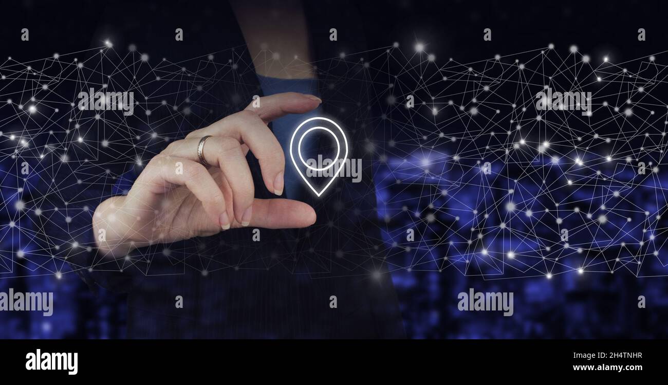 Carte GPS, emplacement de l'adresse PIN.Main tenir l'hologramme numérique emplacement marqueur sur ville sombre arrière-plan flou Banque D'Images