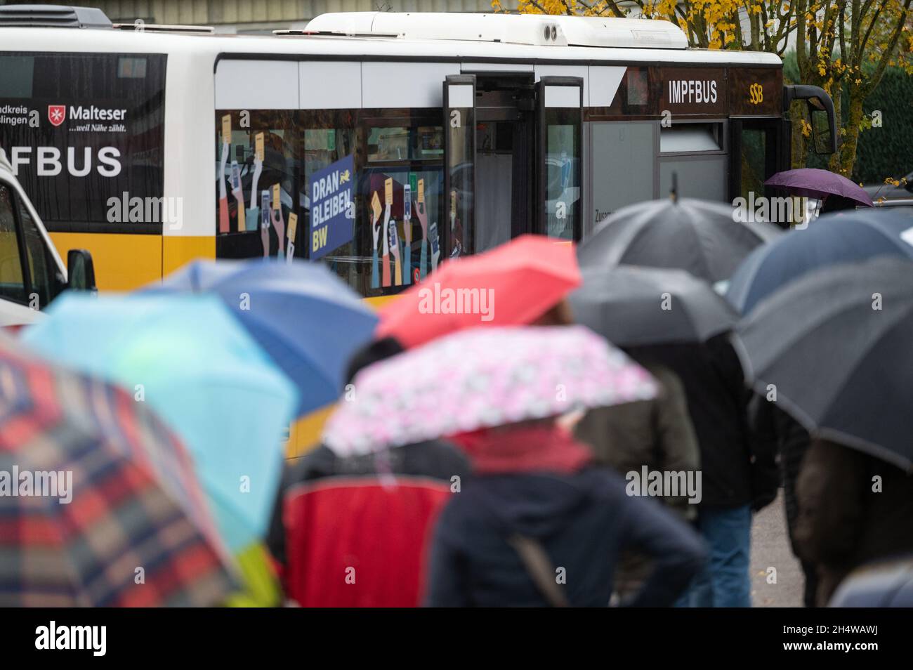 Notzingen, Allemagne.04e novembre 2021.Les gens attendent en ligne avec des parapluies devant un bus de vaccination.Credit: Marijan Murat/dpa/Alamy Live News Banque D'Images