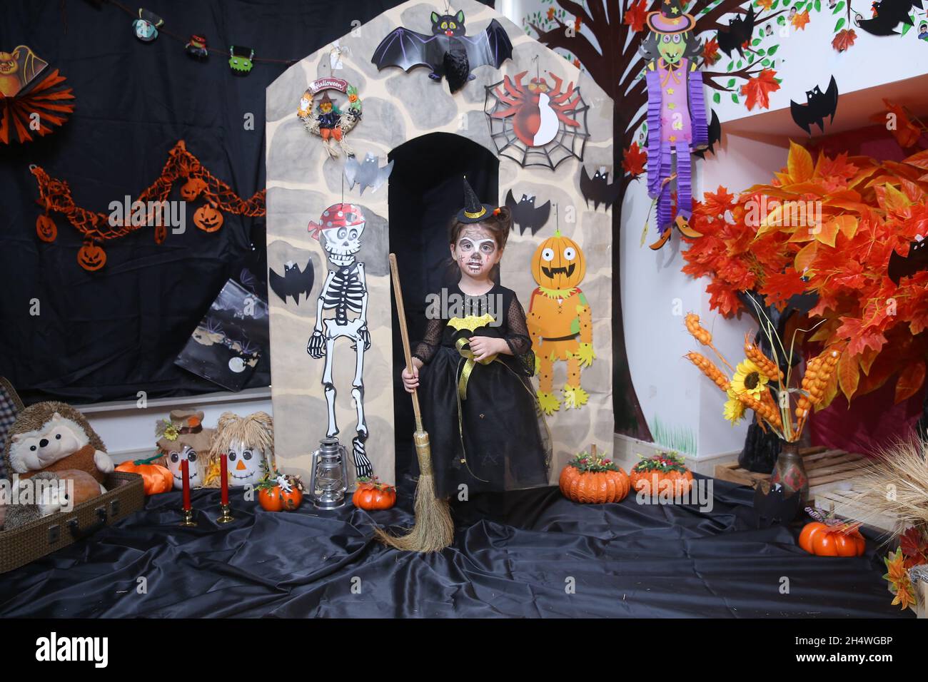 Azerbaïdjan Bakou .01.11.2021 .Une petite fille, sous la forme d'une sorcière sur un bâtonnet, pose sur fond de citrouilles les vacances d'Halloween .Fille Banque D'Images