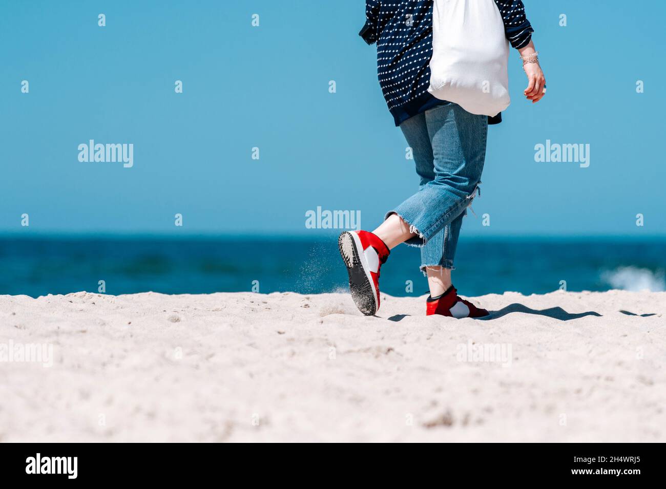 Femme avec sac écologique marchant sur une plage Banque D'Images