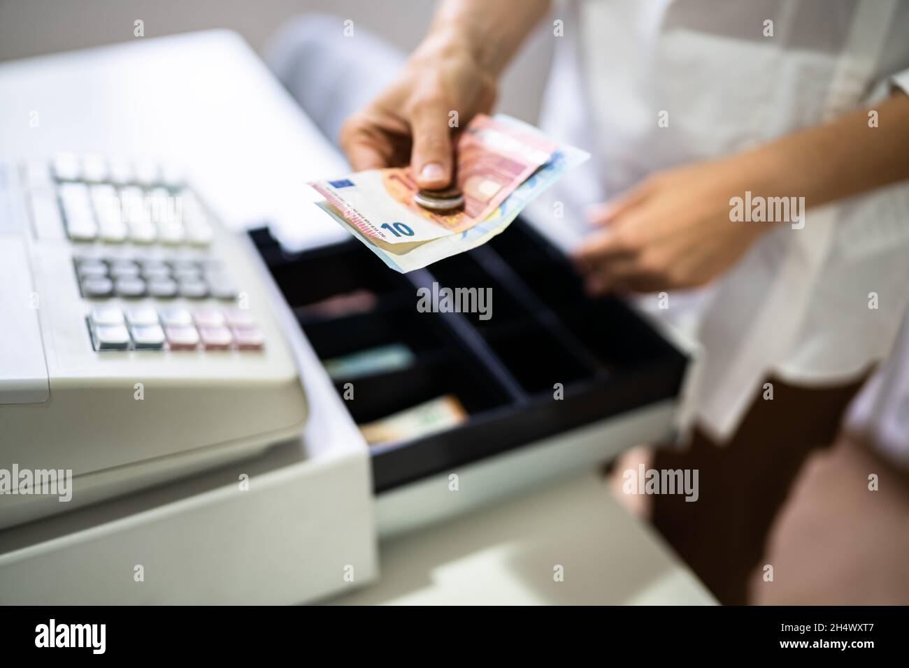 Main du caissier travailler avec la caisse enregistreuse changer la facture  d'argent Photo Stock - Alamy