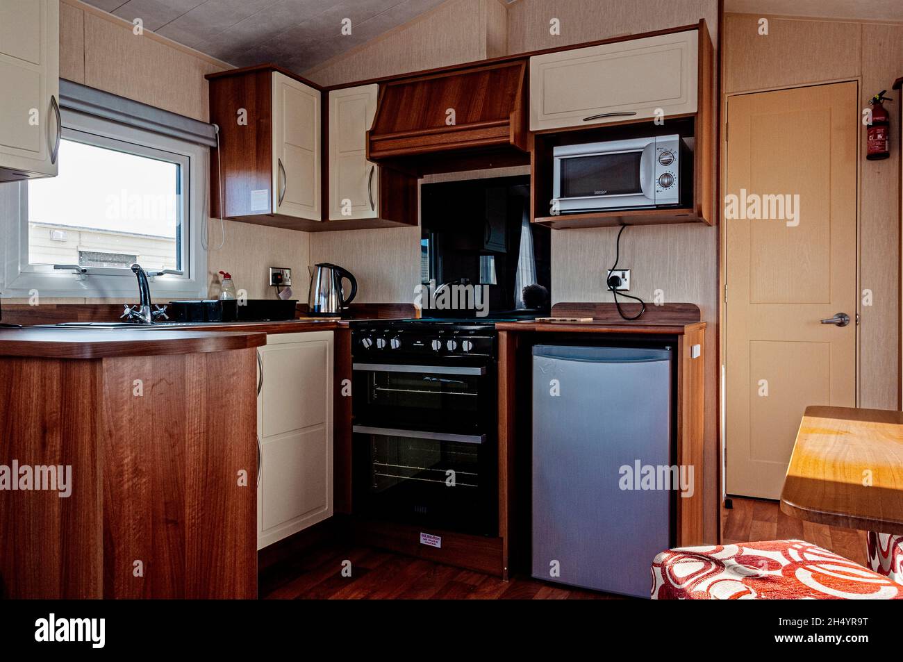 L'utilisation attrayante des lambris et des meubles en bois pour fournir un  espace lumineux, spacieux, salle à manger et cuisine avec beaucoup d'espace de  placard à l'intérieur d'une caravane Photo Stock -