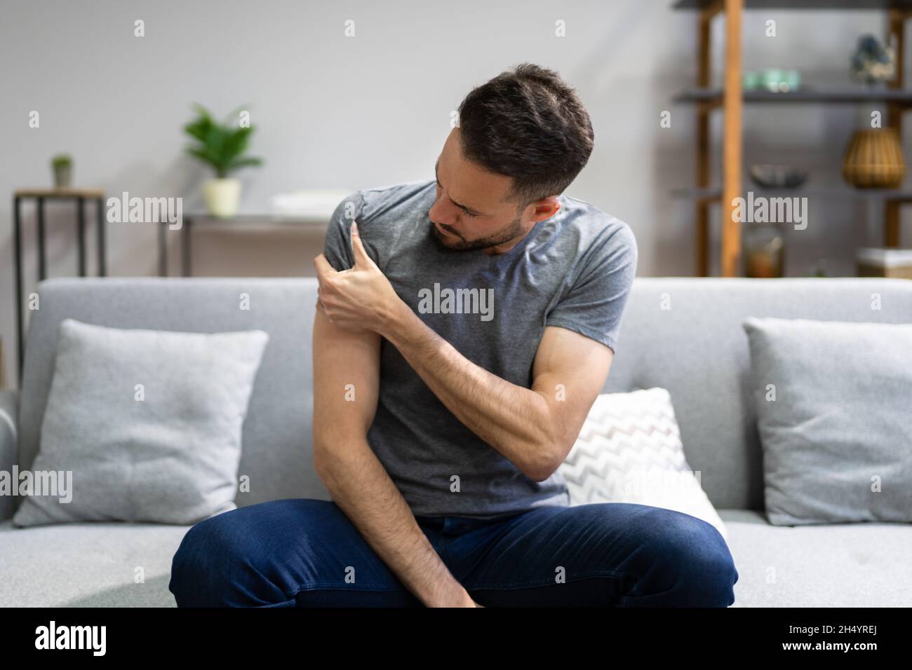 Homme souffrant de douleurs aux épaules à la table de traitement à domicile Banque D'Images