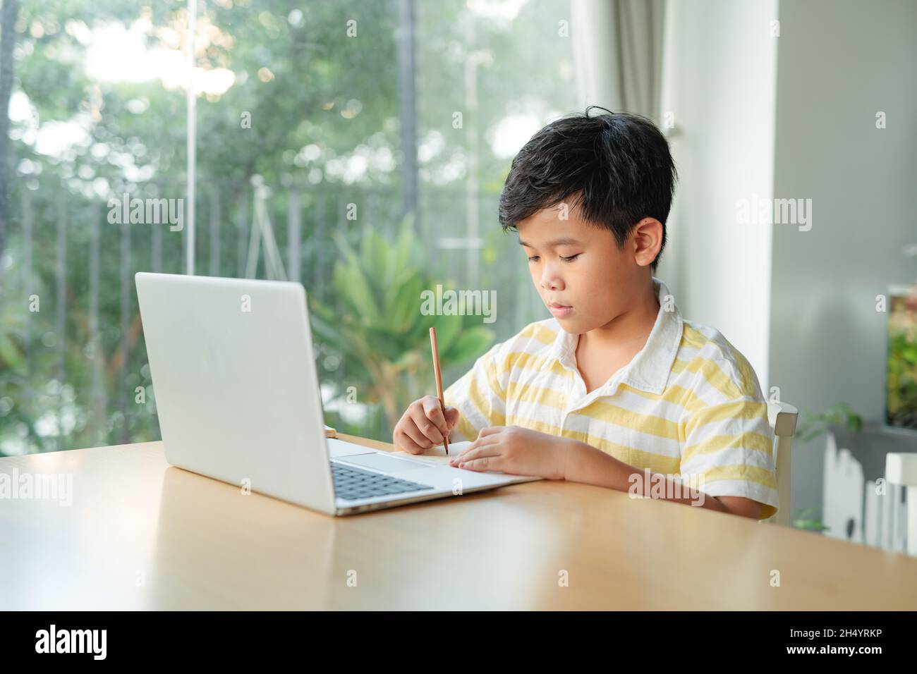 Petit garçon en classe virtuelle. École à la maison Banque D'Images