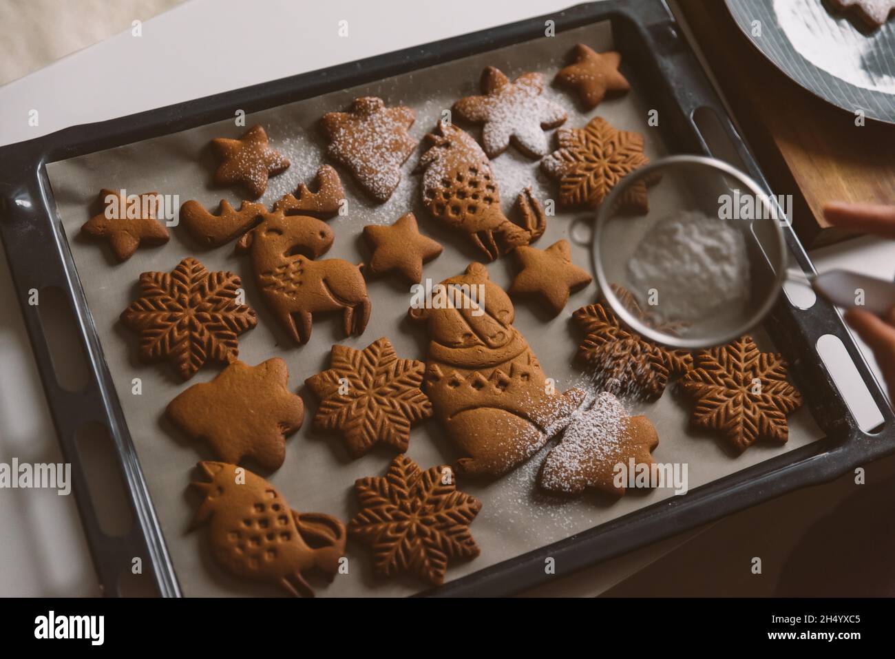 Dépoussiérage d'un pain d'épice de Noël différentes formes animaux, flocons de neige Banque D'Images
