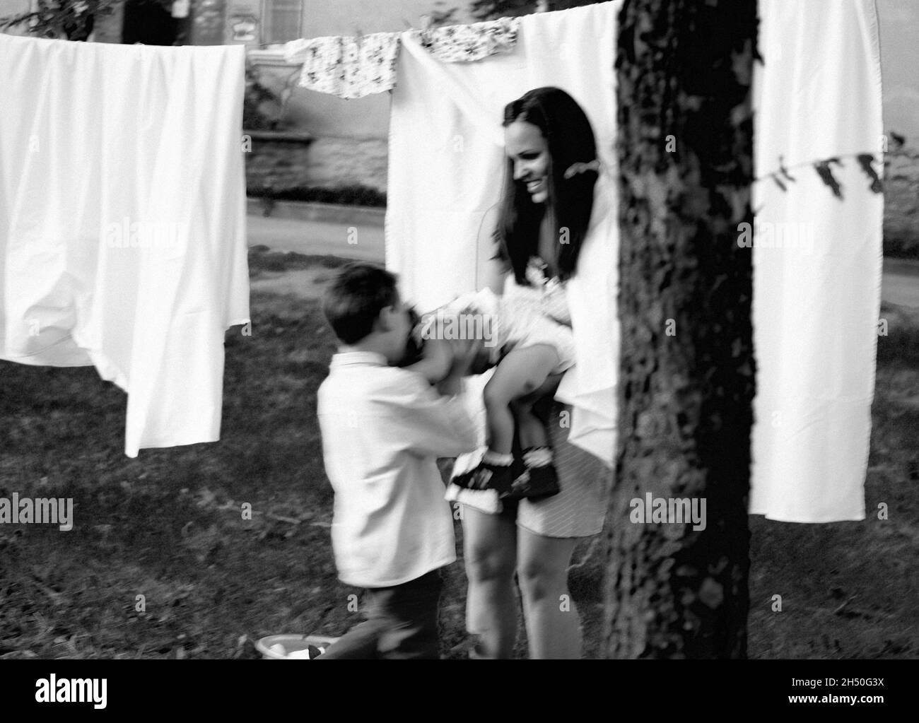 Famille heureuse de faire la lessive à l'extérieur, aider les enfants Banque D'Images