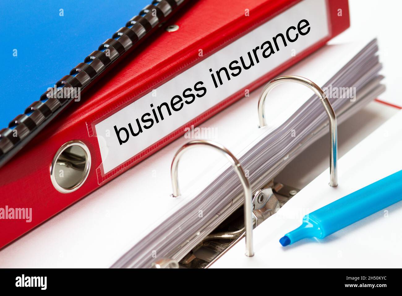 grande chemise rouge pour les documents d'assurance d'entreprise, y compris la reliure à anneaux bleus et le fabricant bleu Banque D'Images