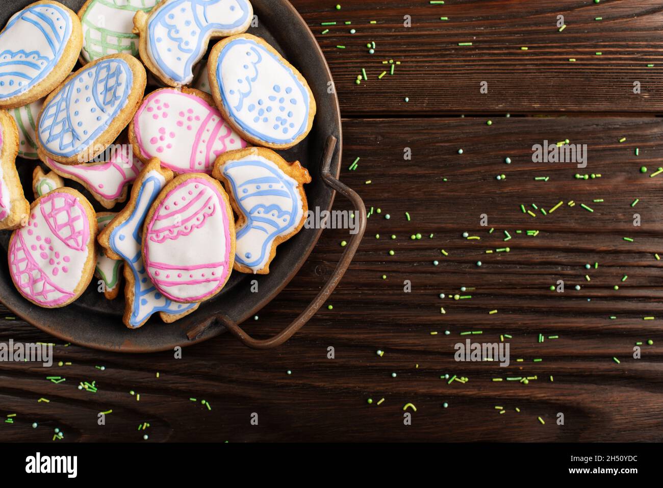 Saupoudrés de sucre et plateau métallique avec biscuits givrés de Pâques en forme de poulet à l'œuf et de lapin sur fond de table en bois.Maquette de pose à plat avec copie sp Banque D'Images