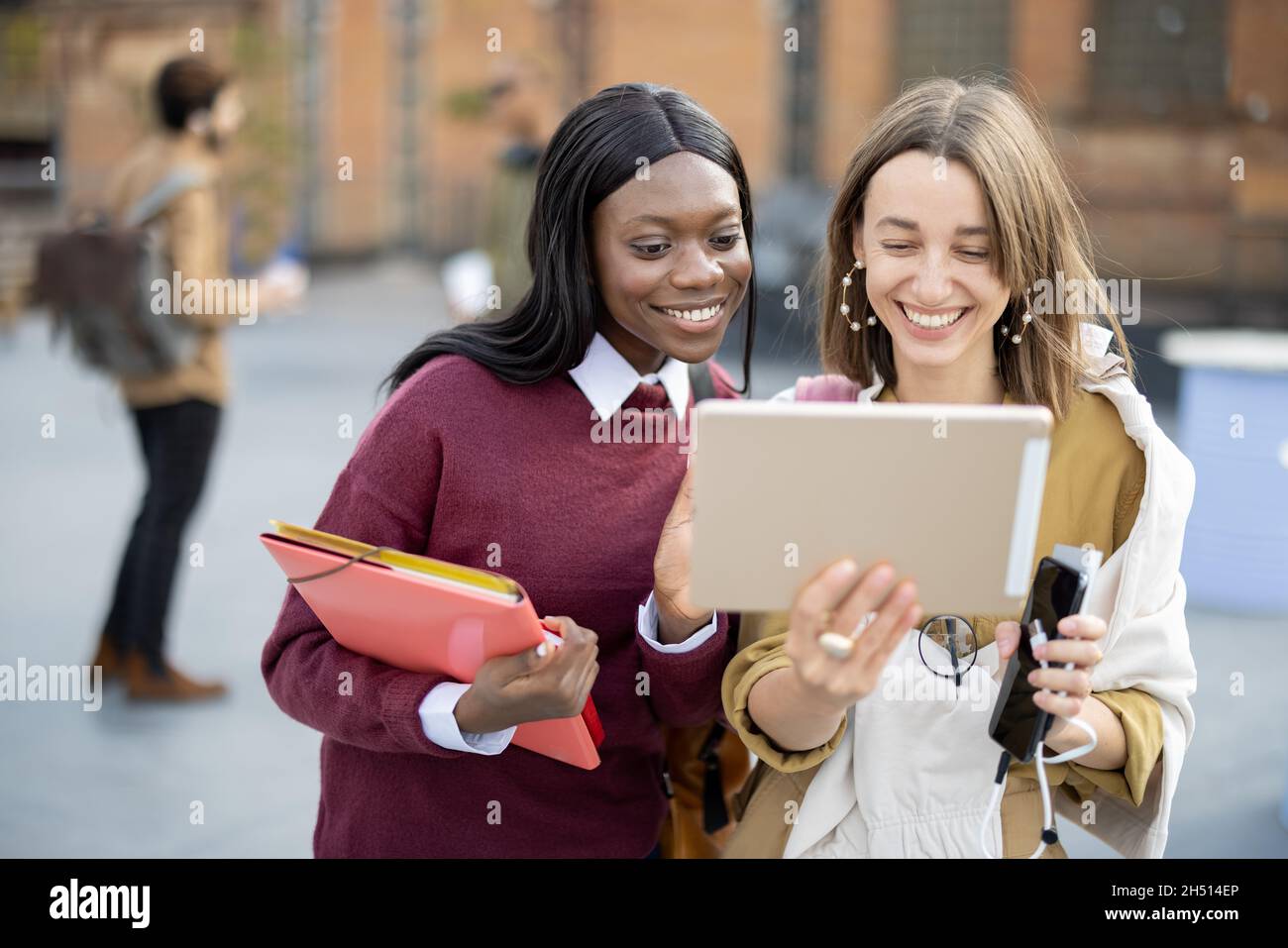 Des étudiantes regardent quelque chose sur une tablette numérique Banque D'Images