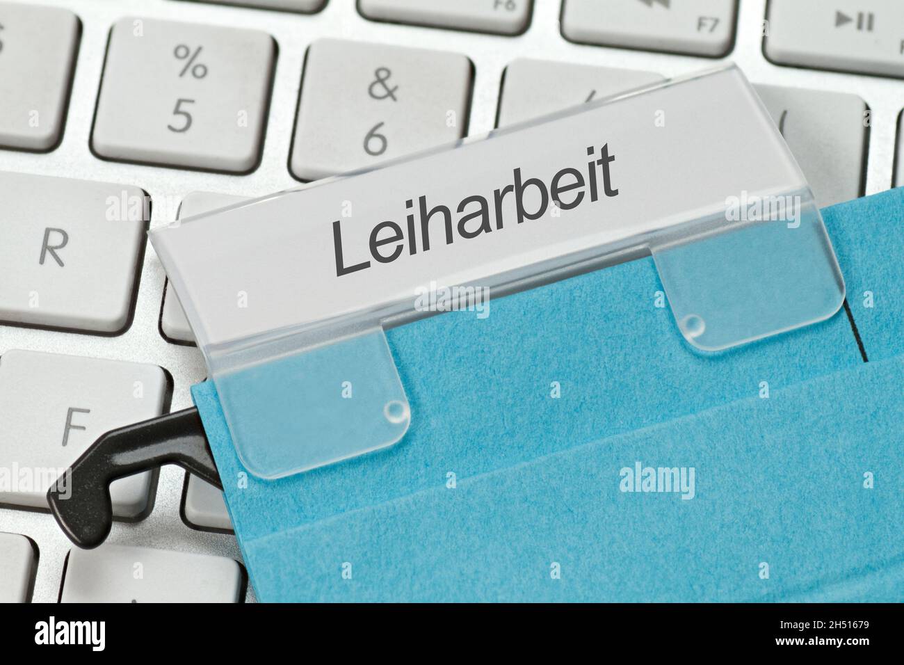 Le mot allemand pour le travail temporaire est écrit sur un onglet d'un fichier suspendu.Se trouve sur un clavier blanc d'ordinateur Banque D'Images