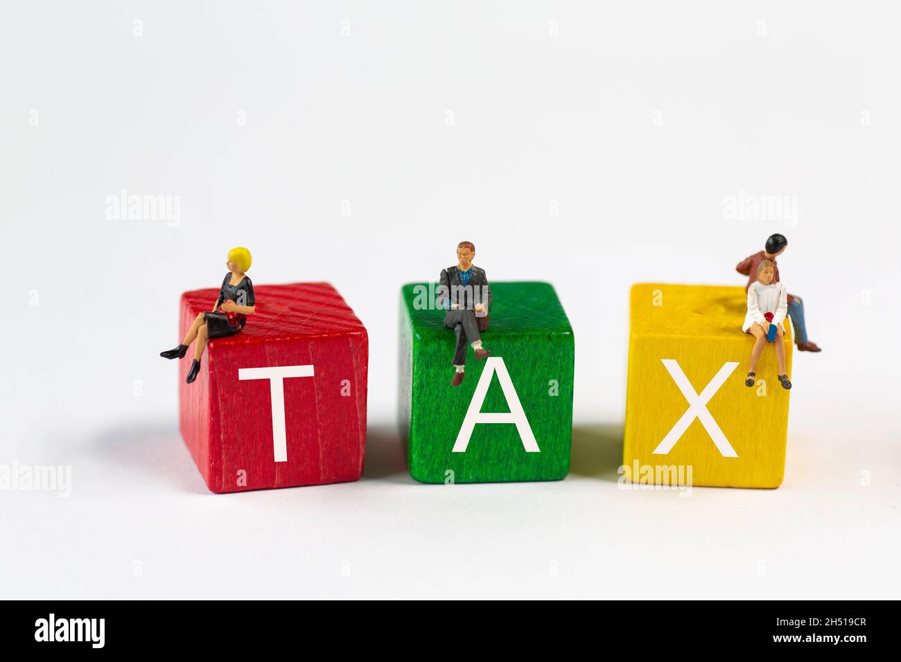 Blocs de jouets de couleur avec des petits personnages assis et le texte: TAXE Banque D'Images