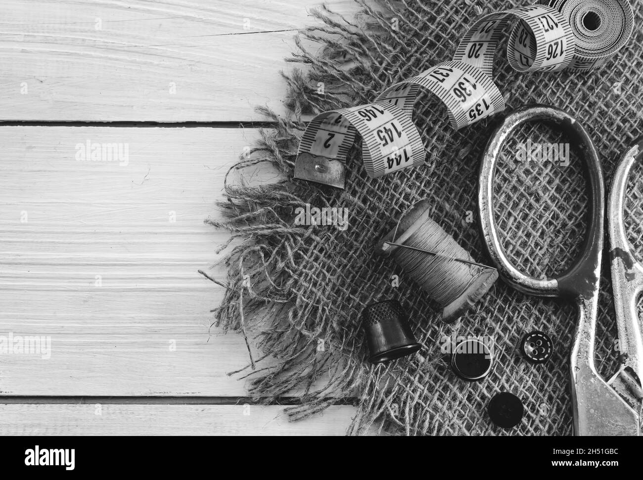 Outils rétro pour le travail d'un tailleur, couturière, designer de mode.Aiguille avec fil, ciseaux, tambour, boutons et centimètre. Banque D'Images