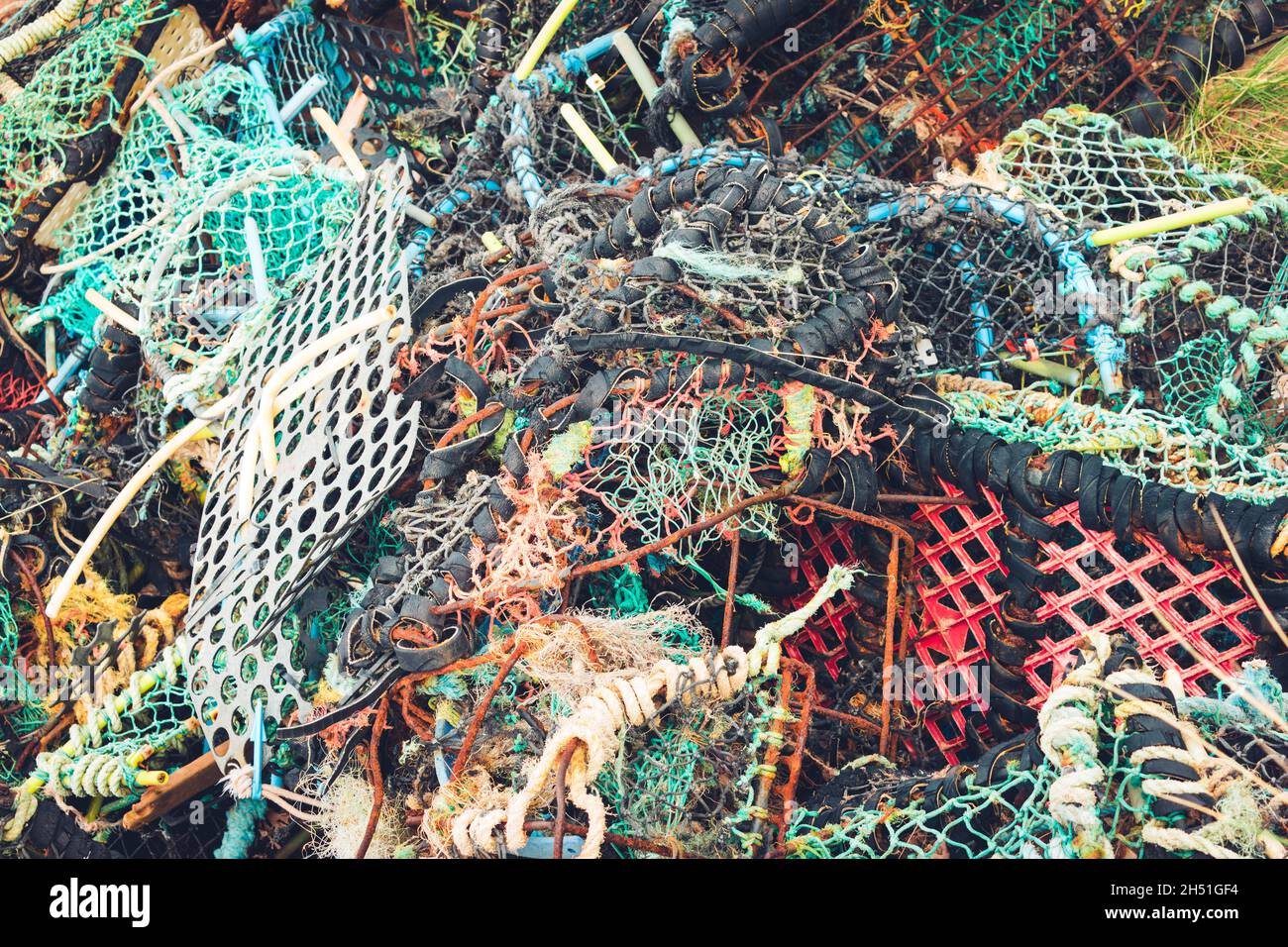 Pile désordonnée de pièges à homard aux couleurs vives et de filets fantômes - débris marins Banque D'Images