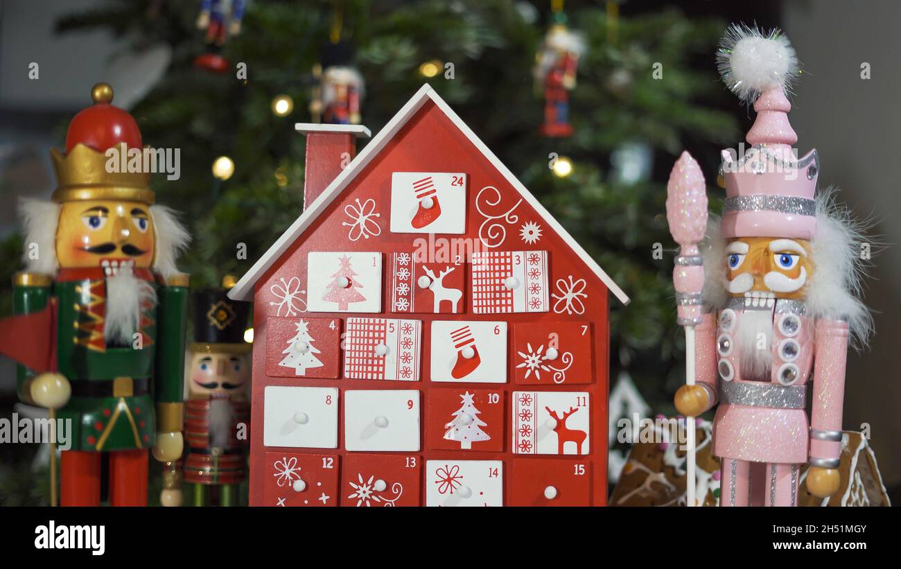 Calendrier de l'Avent des arbres en bois devant un véritable arbre de Noël décoré casse-noisette Soldier Toys.Lumières de fées sur un arbre de Noël avec Backgro flou Banque D'Images