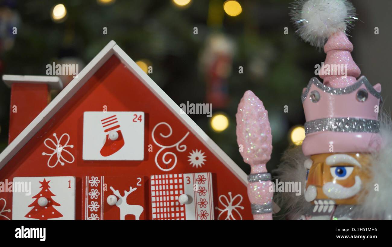 Calendrier de l'Avent des arbres en bois devant un véritable arbre de Noël décoré casse-noisette Soldier Toys.Lumières de fées sur un arbre de Noël avec Backgro flou Banque D'Images