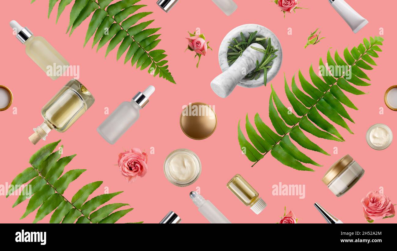 Fond plat et inclinable de compte-gouttes et de flacons pulvérisateurs avec boutons roses, feuilles de fougère et mortier isolés sur du rose.Concept de cosmétiques à base de plantes Banque D'Images
