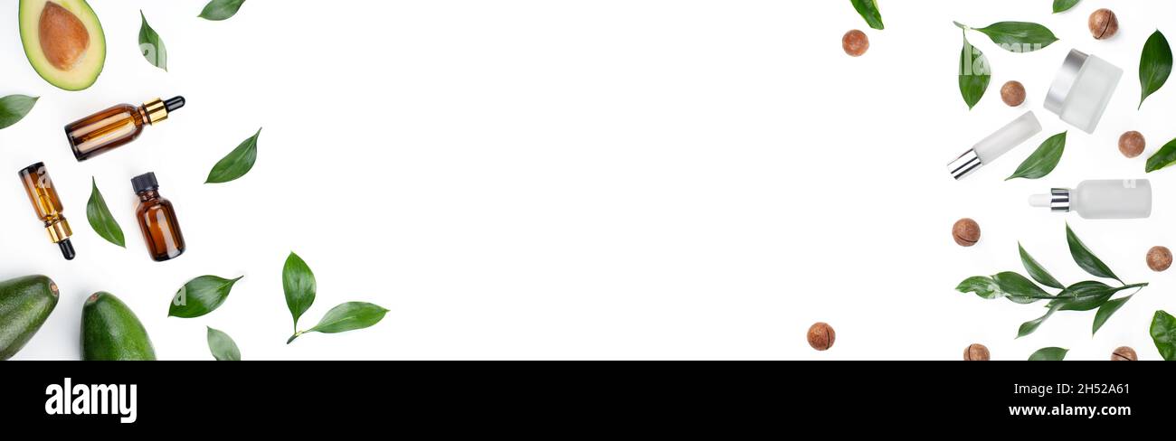 Flacons compte-gouttes avec des macadamias frais mûrs à l'avocat et de l'huile essentielle sur la table blanche Banque D'Images