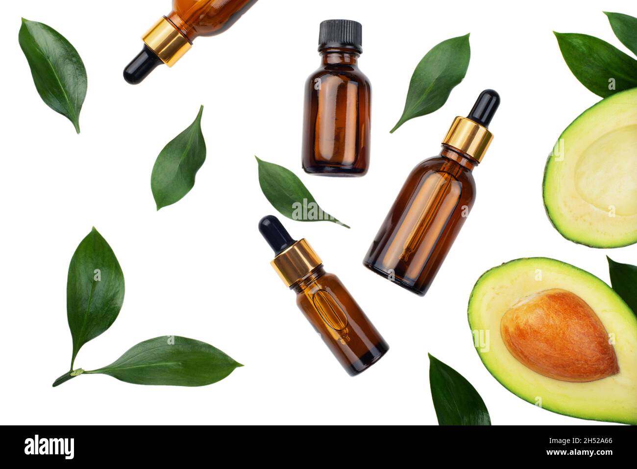Flacons compte-gouttes avec avocat mûr frais et huile essentielle sur table blanche Banque D'Images