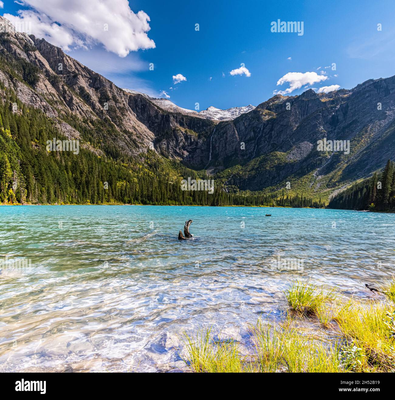 Sommets enneigés du ciel au-dessus de l'eau claire du lac Avalanche, parc national Glacier, Montana, États-Unis Banque D'Images