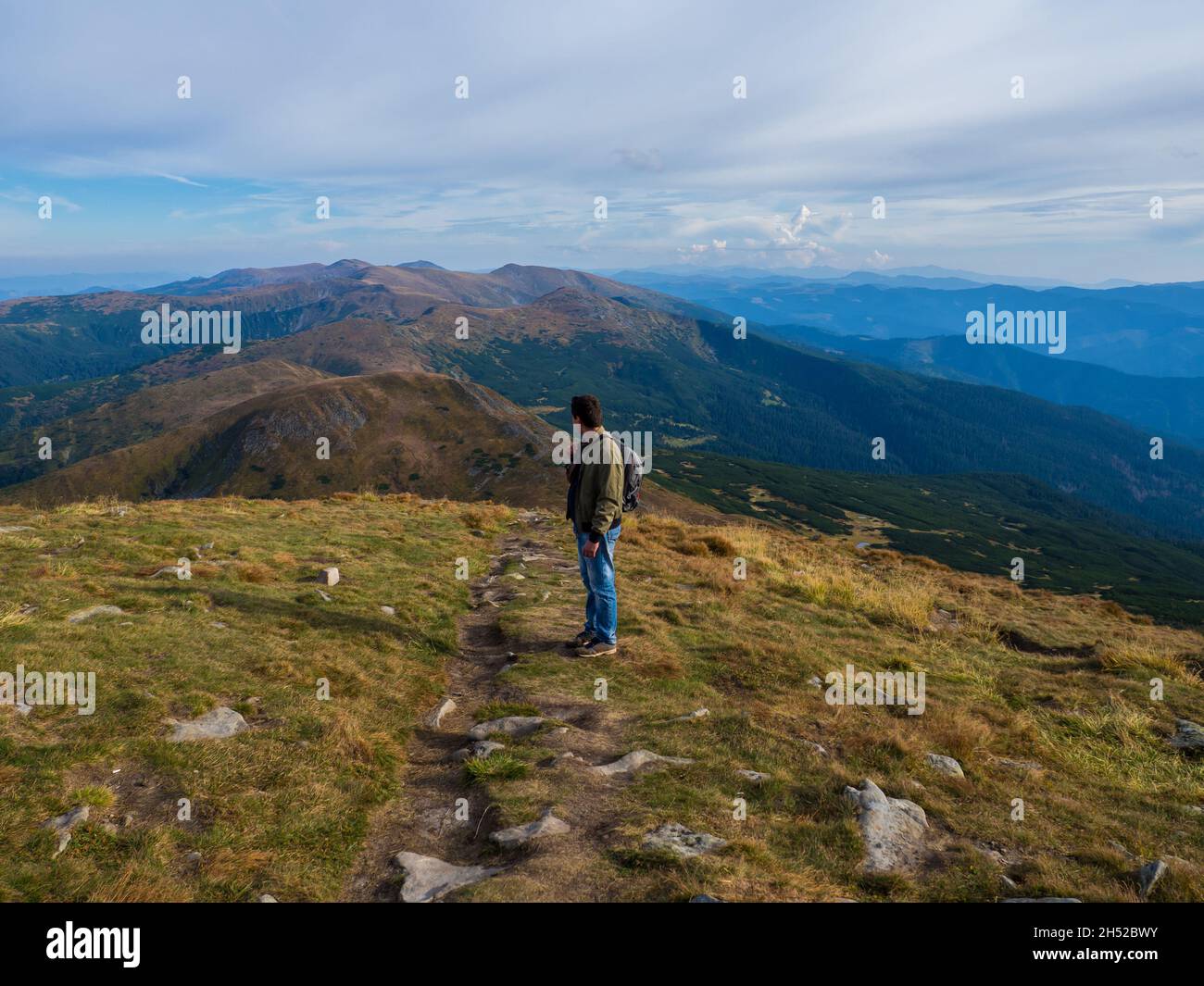 Homme debout au sommet de la montagne se relaxant et appréciant le paysage magnifique Banque D'Images