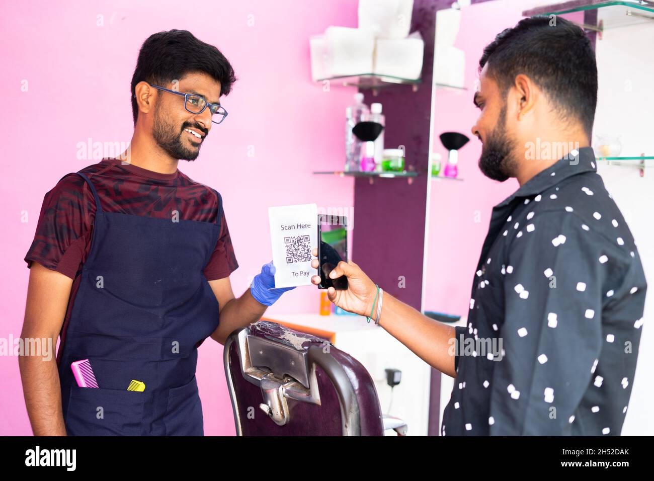 Client scannant le code QR dans smartphone pour faire le paiement à baber à la boutique de coiffure - concept de paiement numérique, technologie sans espèces, recommander E Banque D'Images