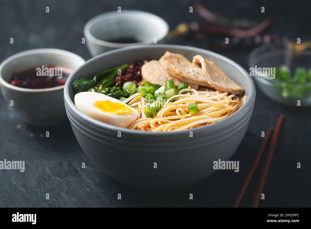 Le ramen est des nouilles asiatiques dans un bol avec de la viande et des légumes ou des fruits de mer, souvent aromatisés avec de la sauce de soja ou du miso.Arrière-plan sombre Banque D'Images