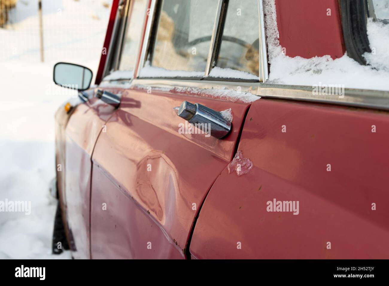 vieille voiture rétro brisée rouge rouillé vieux garé en hiver sur fond de neige le jour d'hiver glacial Banque D'Images