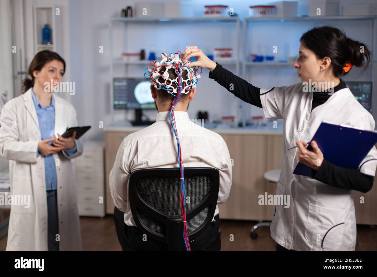 Équipe médicale de neurologues ajustement EEG du cerveau analyse de l'évolution du système nerveux du patient humain au cours d'une expérience clinique en laboratoire de neuroscience.Médecin médecin médecin surveillant l'activité neurologique Banque D'Images