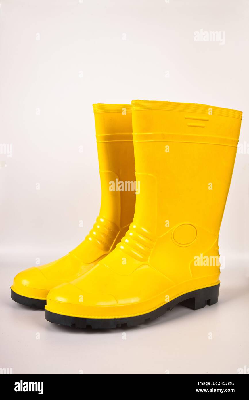 Bottes en caoutchouc jaune robustes et étanches isolées sur fond blanc Banque D'Images