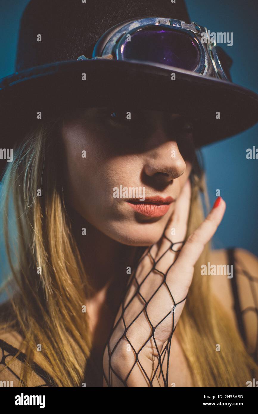 Portrait d'une belle femme blonde portant un chapeau fedora et des gants de résille Banque D'Images