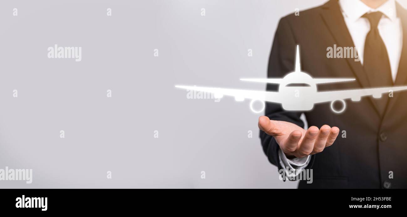 Homme d'affaires tenant une icône d'avion dans ses mains.Achat de billets en ligne.Voyage Banque D'Images