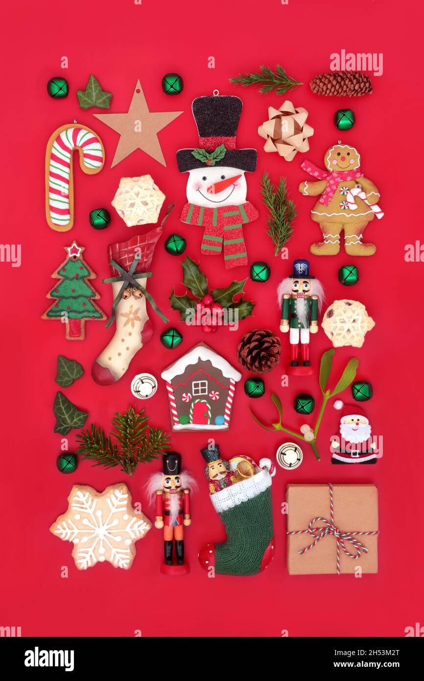 Décorations de Noël traditionnelles, nourriture et flore d'hiver sur fond rouge.Composition Noël pour les fêtes.Vue de dessus. Banque D'Images