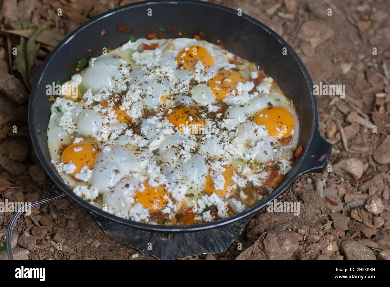Shakshouka, un plat traditionnel d'œufs pochés en sauce aux tomates, à la harissa, à l'huile d'olive, à l'oignon, à l'ail et aux épices,bouillie dans une casserole à l'extérieur Banque D'Images