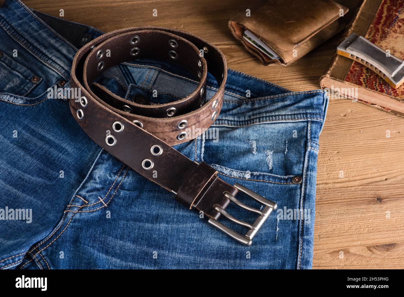 Ceinture en cuir véritable gros plan style rock sur fond de  bois.Accessoires pour hommes et jeans bleus Photo Stock - Alamy