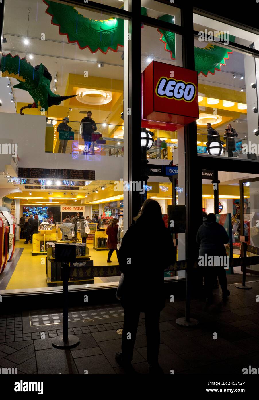 Les gens marchent devant le magasin Lego la nuit dans le West End de Londres, Angleterre, Royaume-Uni Banque D'Images