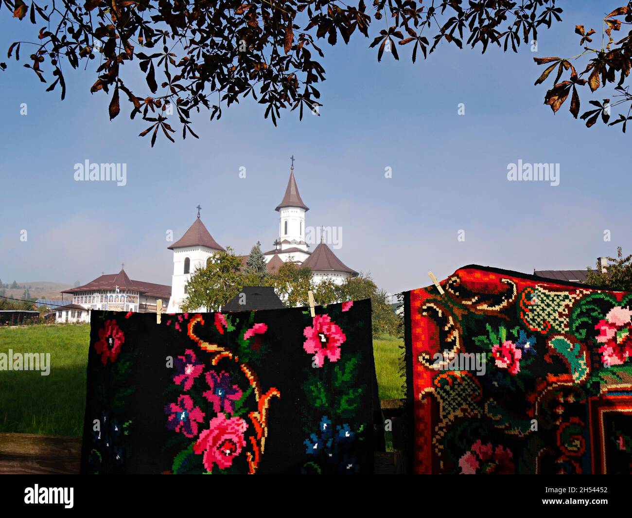 Tapis traditionnels lumineux avec monastère peint en arrière-plan, Roumanie Banque D'Images