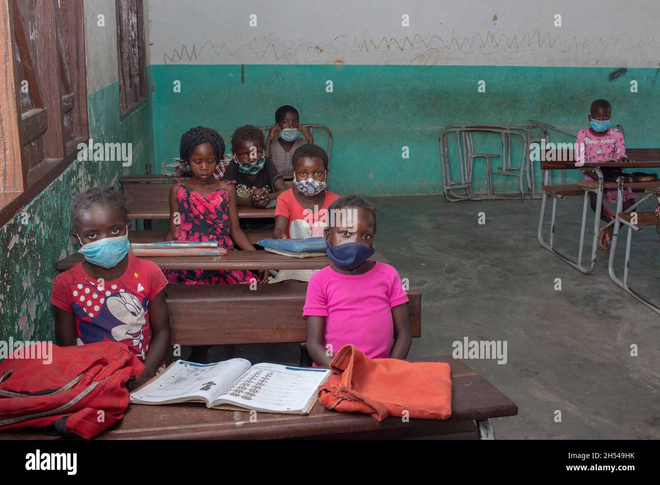 Les écoliers de retour à l'école dans une salle de classe, distancé et portant des masques de visage, se empêchant de covid-19. Banque D'Images