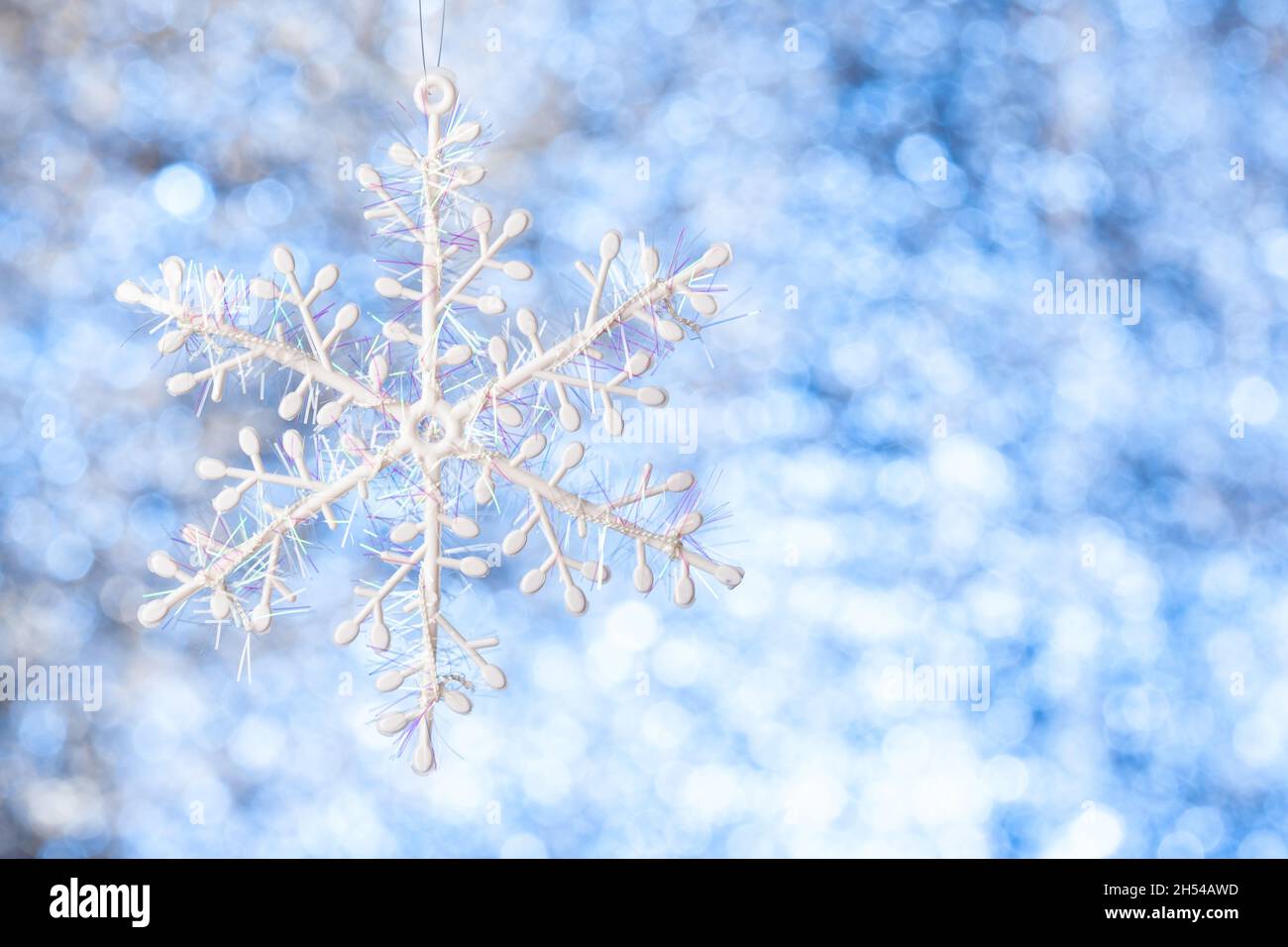 flocon de neige blanc sur un arrière-plan blanc-bleu brillant et flou.Copier l'espace.Modèle pour la conception Banque D'Images