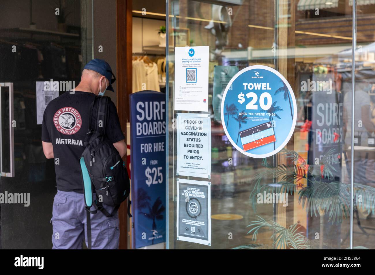 Un homme entrant dans le surf shop Manly Beach Sydney s'enregistre à l'aide de l'application Service NSW qr et montre une preuve de vaccination due à un covid Banque D'Images