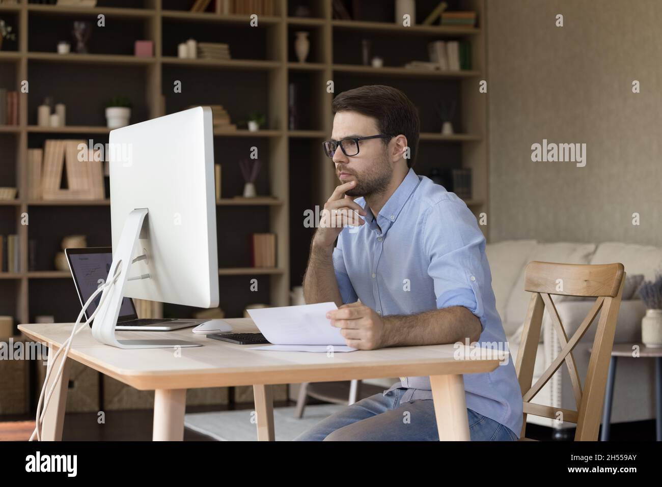 Concentré SMART 30s jeune homme directeur travaillant dans le bureau moderne. Banque D'Images