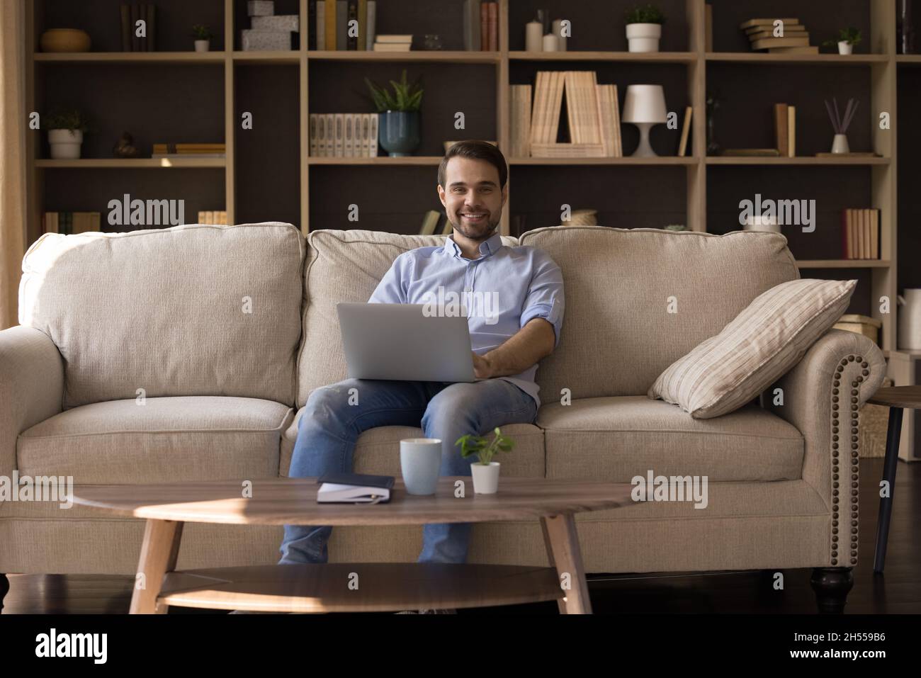 Portrait d'un jeune homme heureux avec ordinateur sur les tours. Banque D'Images