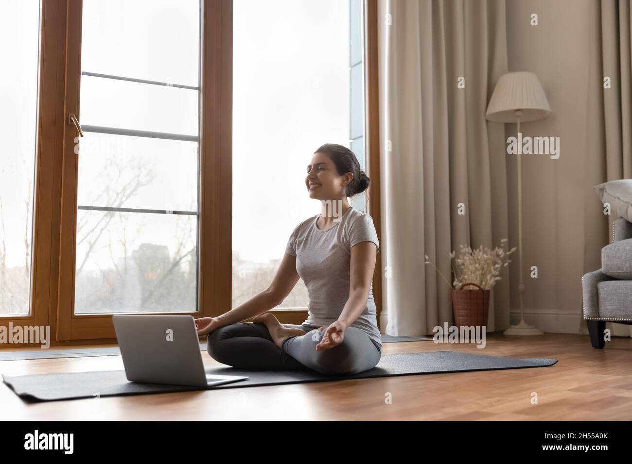 Sereine femme indienne entraîneur de conduire en ligne classe de méditation de yoga Banque D'Images