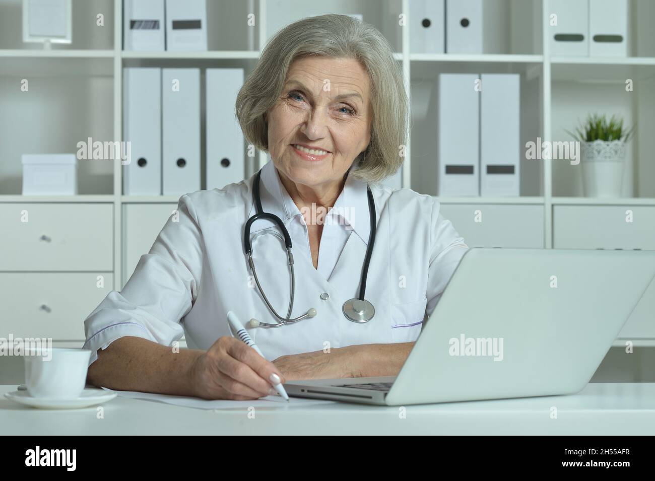 Femme médecin senior travaillant dans son cabinet Banque D'Images