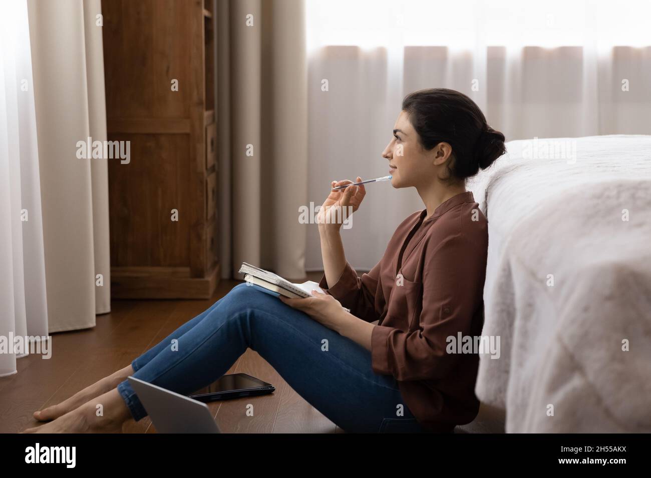 Femme indienne porte un stylo et un carnet en papier à l'aspect inspiré Banque D'Images