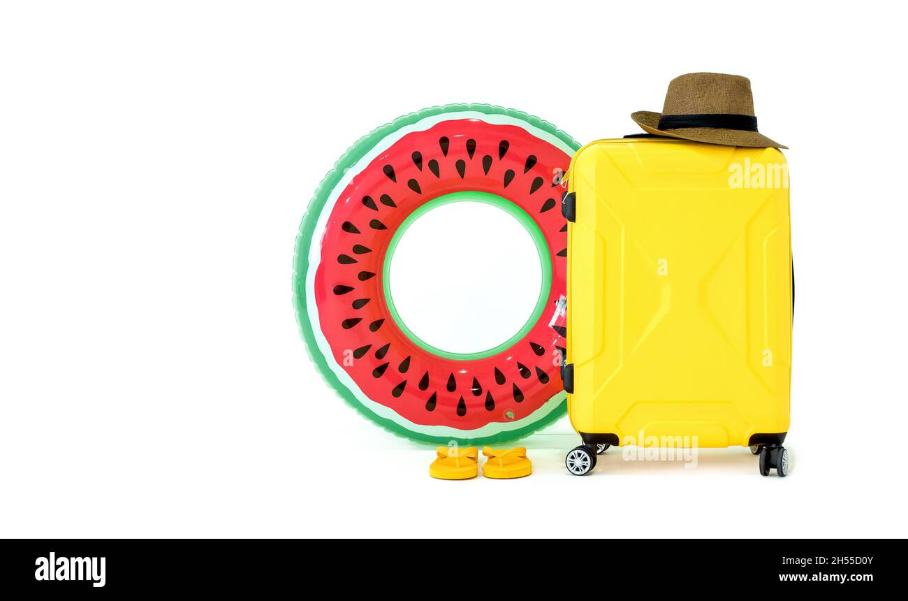 Concept de voyage d'été.Ballons gonflables colorés, sandales, valise jaune et chapeau de paille avec une bande noire sur fond blanc.(Prise de vue en studio) Banque D'Images